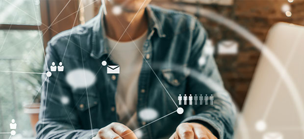 Persona utilizando un ordenador con iconos de personas y conexiones digitales, representando los servicios de outsourcing para la gestión de Salesforce CRM